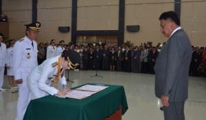 Bupati Minsel Christiany Eugenia Paruntu saat menandatangani berita acara pelantikan dihadapan Gubernur Sulut Olly Dondokambey