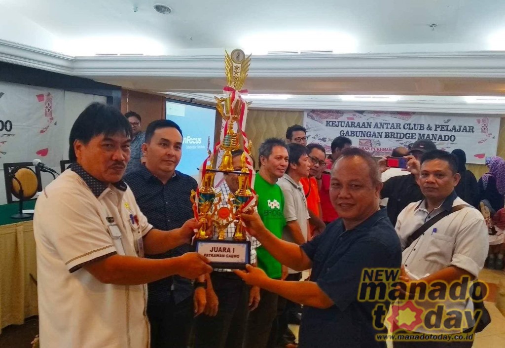 Ketua Harian Gabmo Roy Maramis saat menyerahkan hadiah kepada juara utama Manado Cerdas I yang digawangi Ketua Harke Tulenan